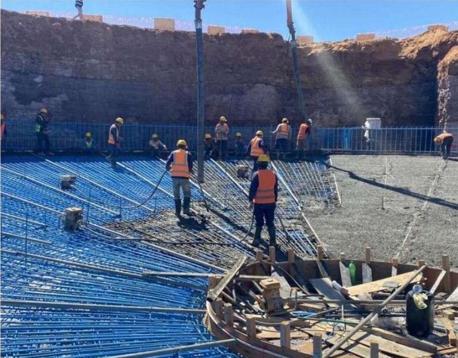 Crew placing concrete over reinforcement